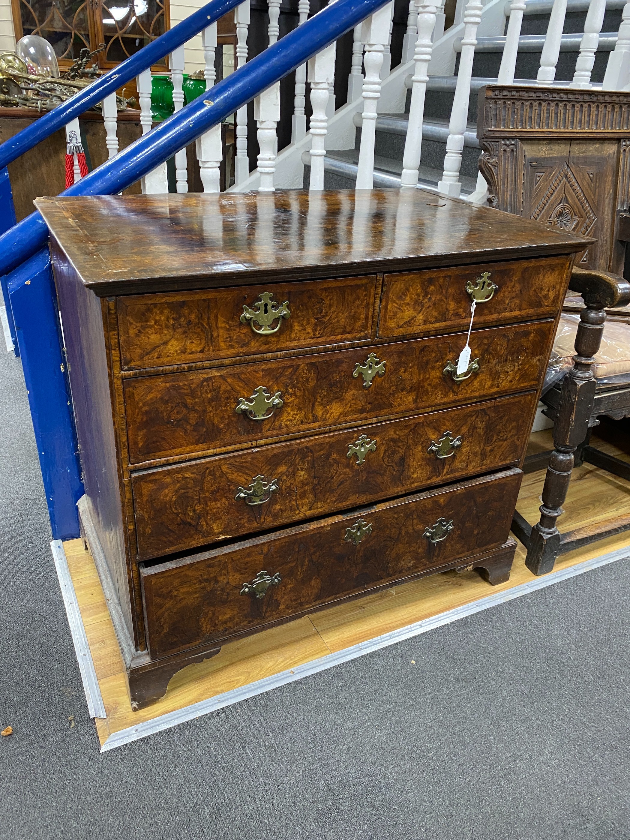 An 18th century feather banded walnut chest of two short and three graduating long drawers, width 96cm, depth 58cm, height 87cm